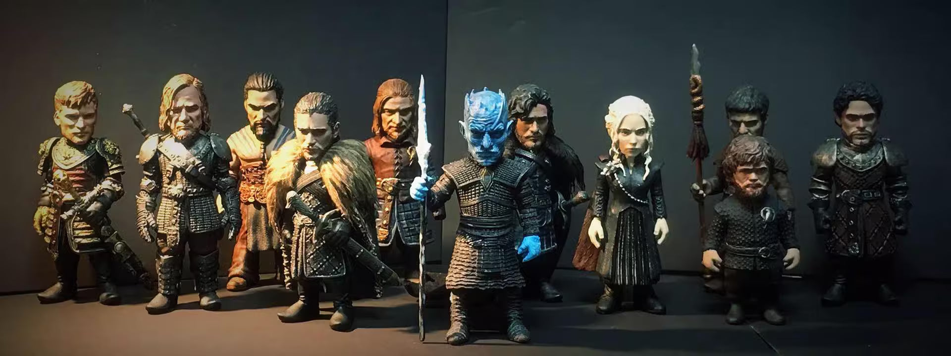 Collection of action figures in various poses against a dark background