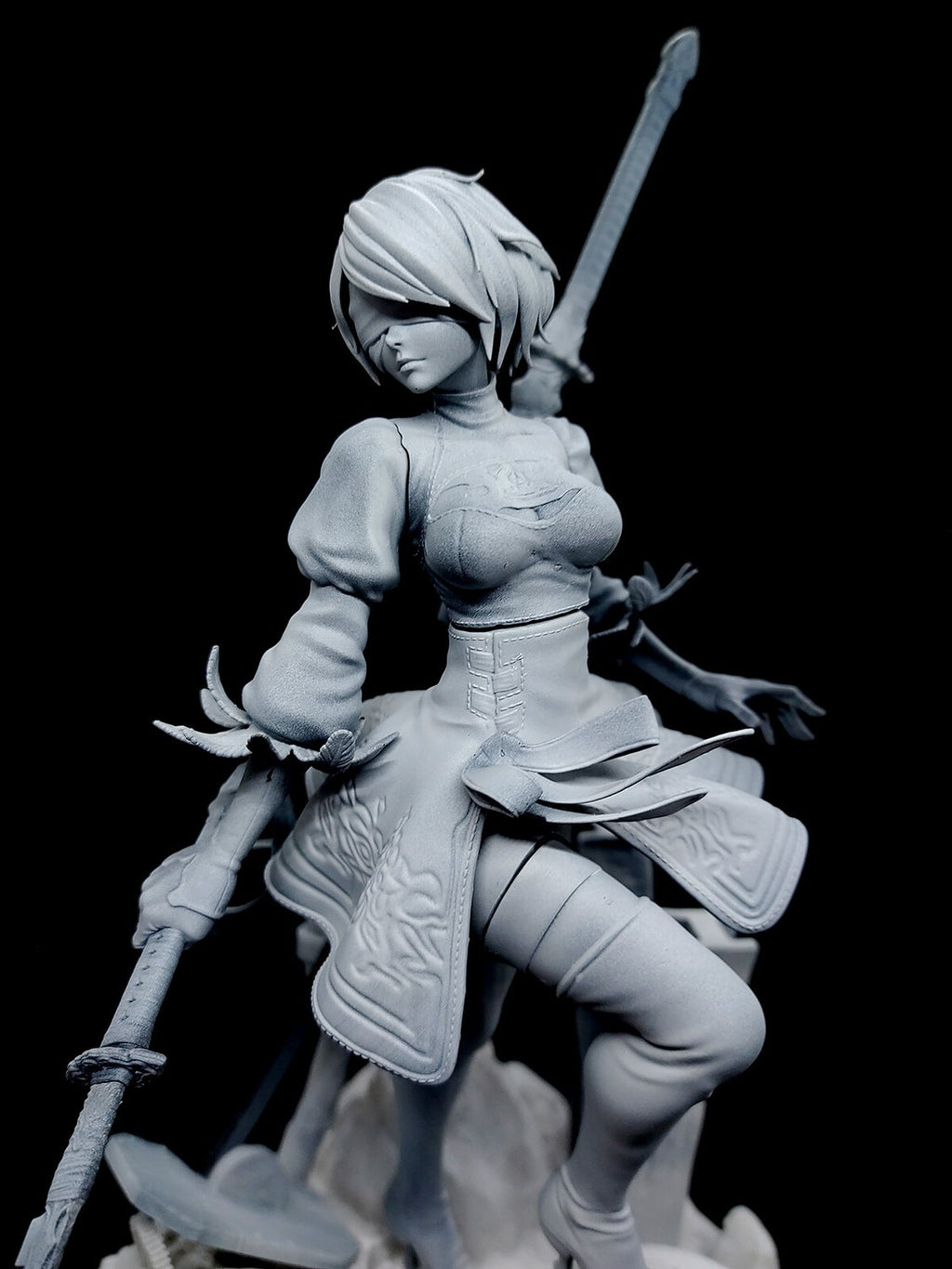 An unpainted gray resin statue of a female warrior character holding a sword, shown against a solid black background.