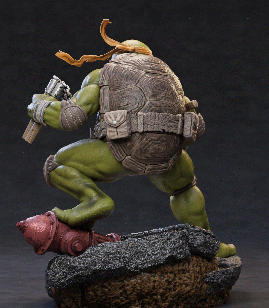 A detailed collectible statue of a green-skinned turtle character in a dynamic crouching pose, mounted on a rocky base with a red object at its feet, photographed against a dark studio background.
