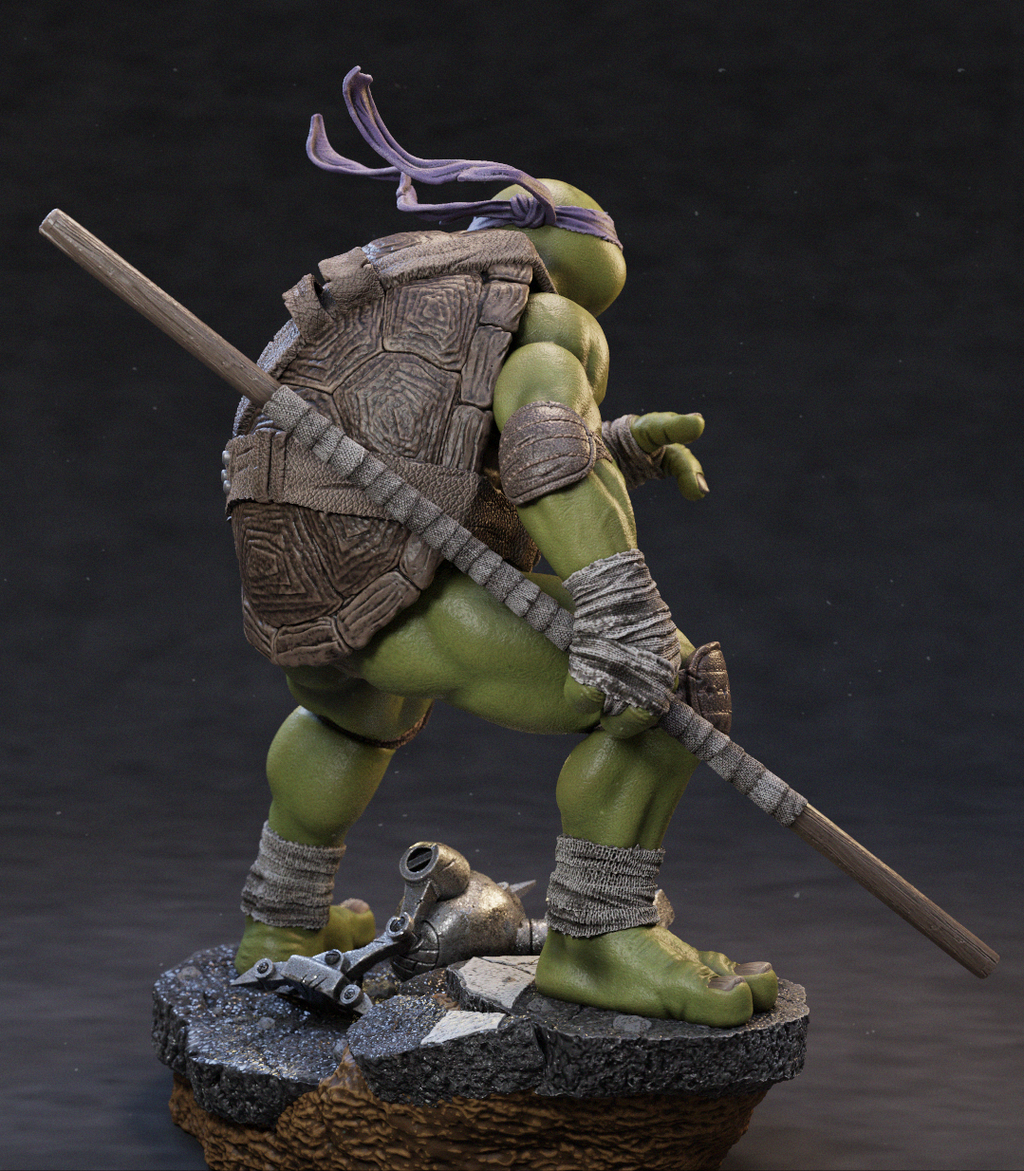 A highly detailed collectible statue of a Teenage Mutant Ninja Turtle in a dynamic pose, standing on a textured base with a staff and a small metallic object. The figure features green skin, a patterned brown shell, purple headband, and gray bandages, set against a dark studio background.