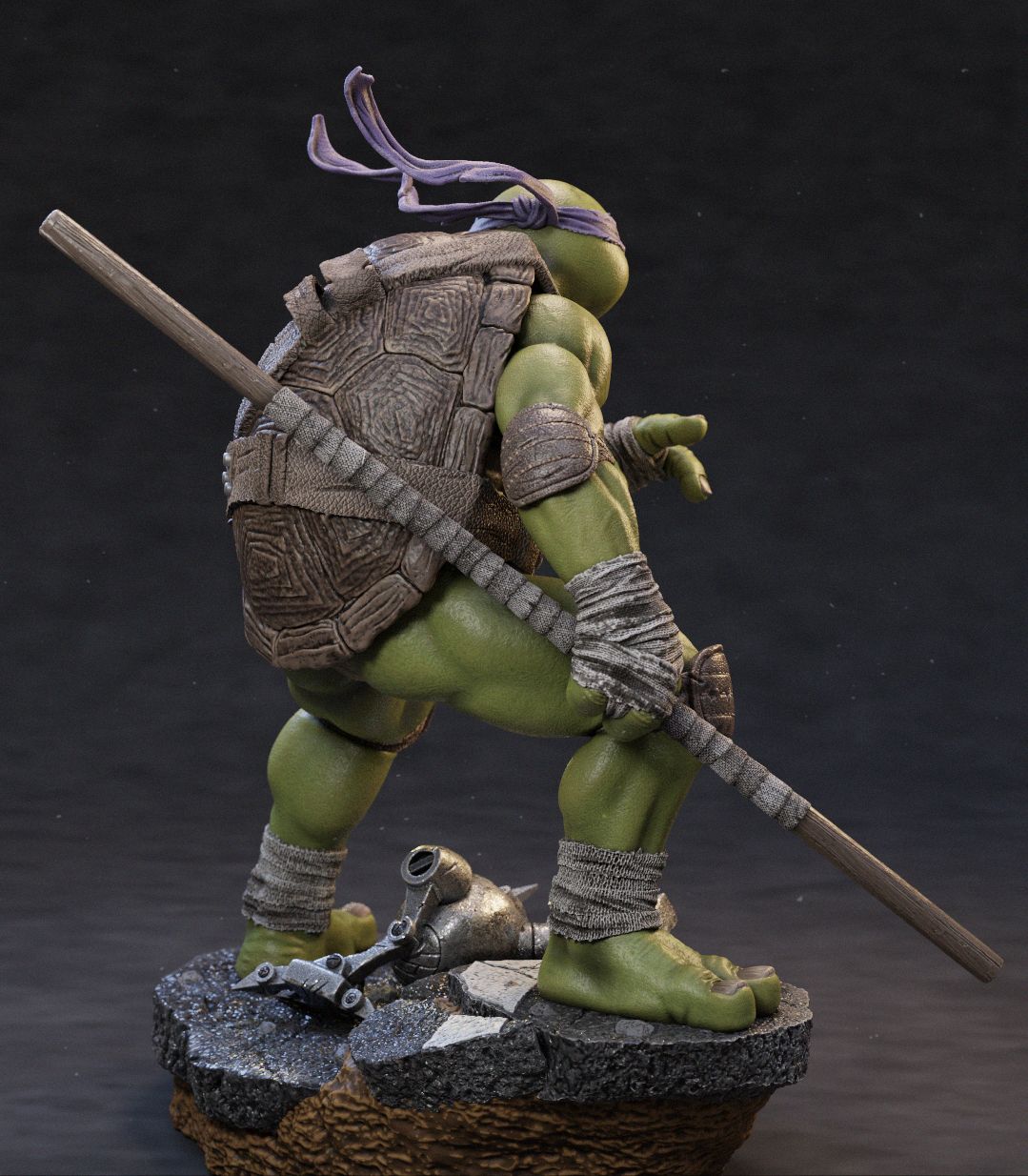 A highly detailed collectible statue of a Teenage Mutant Ninja Turtle in a dynamic pose, standing on a textured base with a staff and a small metallic object. The figure features green skin, a patterned brown shell, purple headband, and gray bandages, set against a dark studio background.