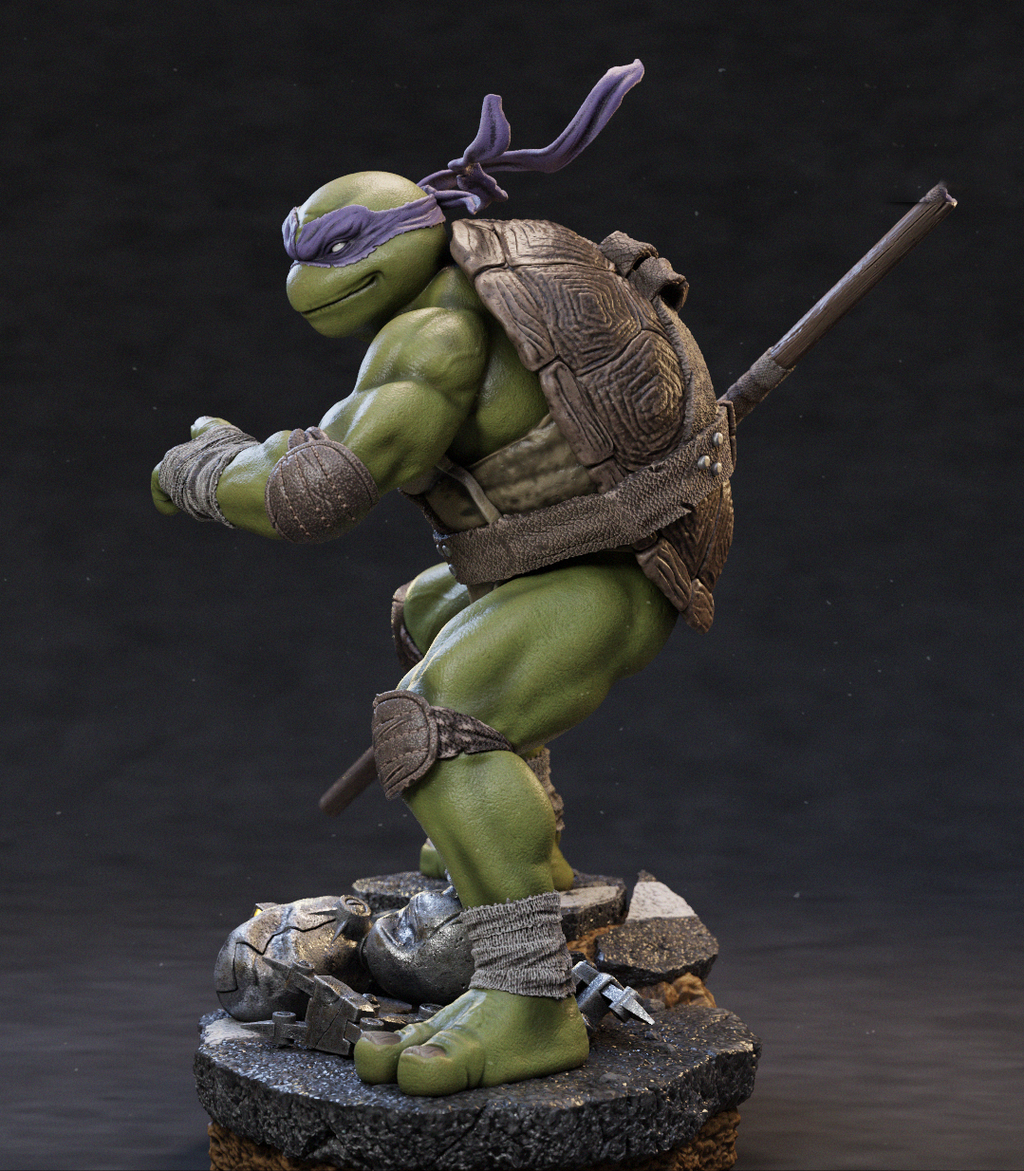 A detailed collectible statue of a green turtle character in a dynamic crouching pose, wearing a purple eye mask and carrying a staff, standing on a rocky base against a dark studio background.