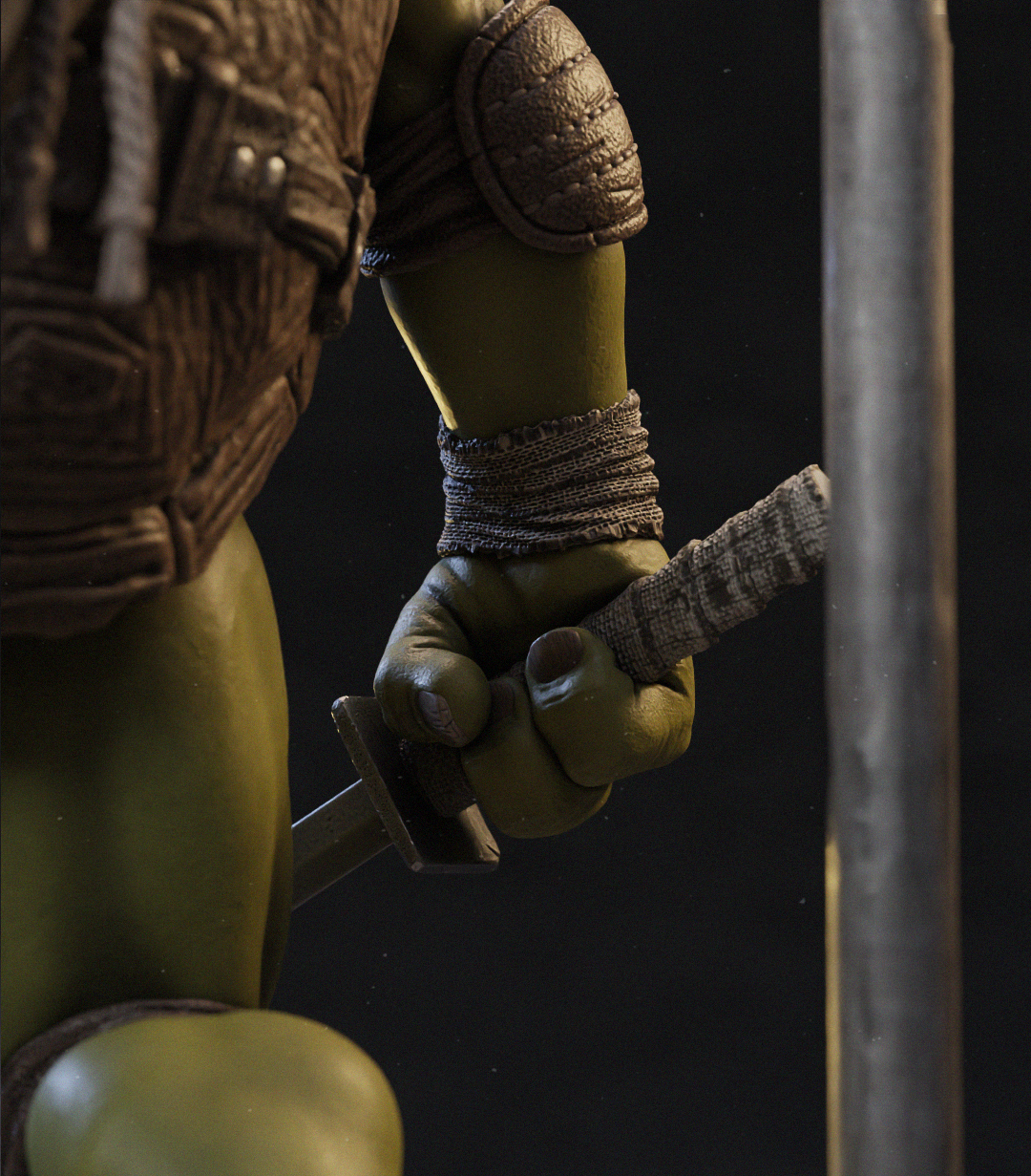 Close-up of a green-skinned action figure or collectible character holding a sword, showing detailed brown armor, textured fabric wrap, and sculpted skin against a dark background.