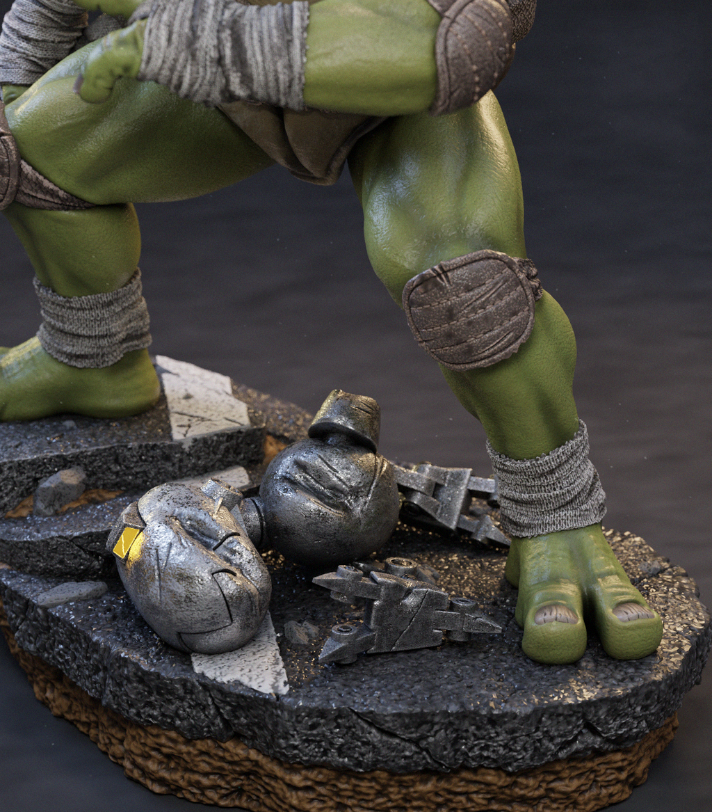Close-up of a green-skinned action figure or collectible statue showing the lower torso and legs, standing on a rocky base with metallic gloves and debris around it.
