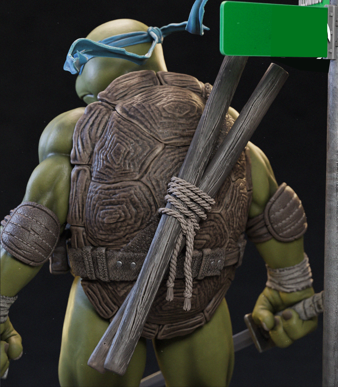 A close-up of a green-skinned action figure from behind, wearing a blue headband and carrying a large brown shell backpack with wooden sticks tied to the back, set against a black background.