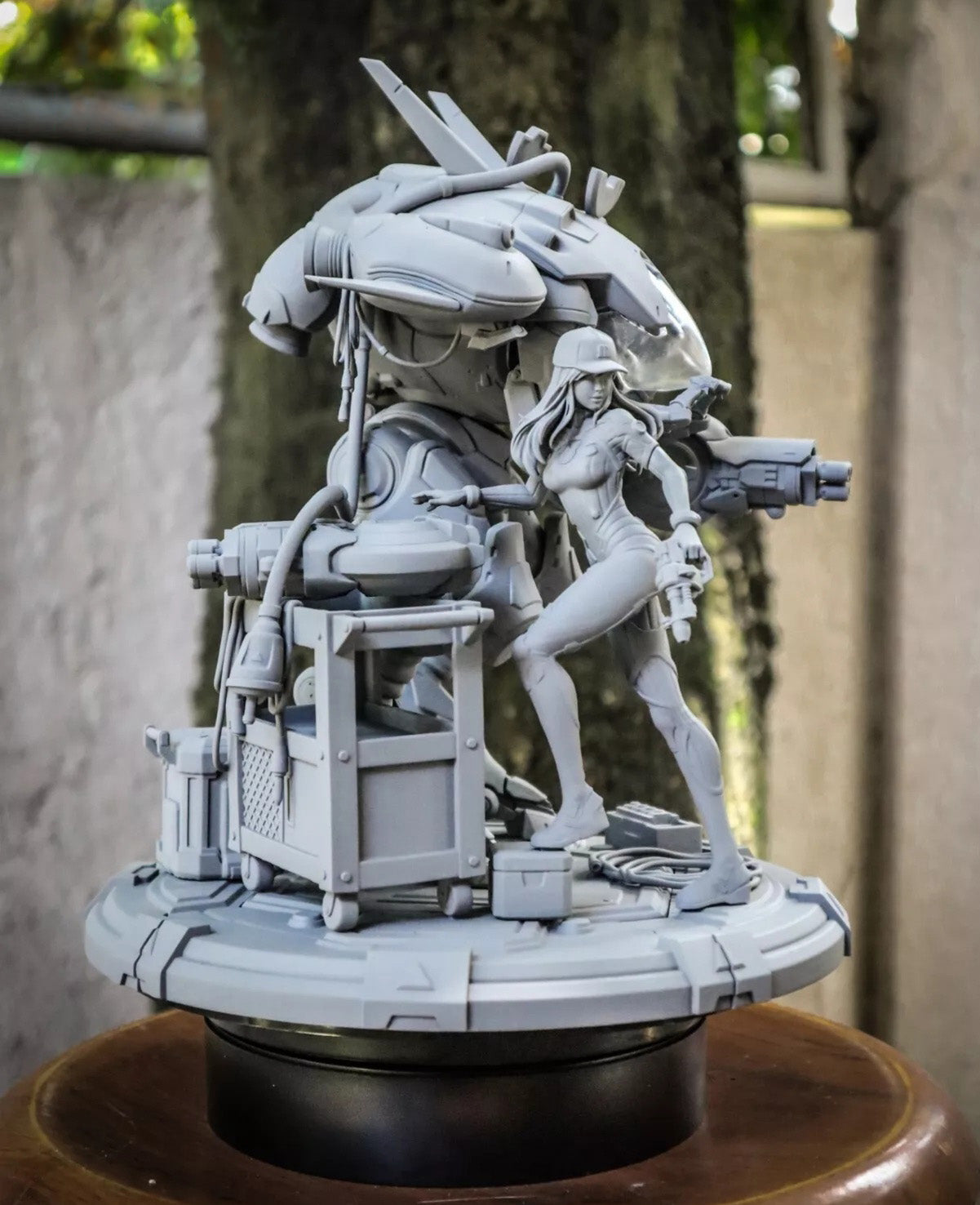 Gray scale model of a futuristic scene with a character and mechanical creature on a wooden surface.