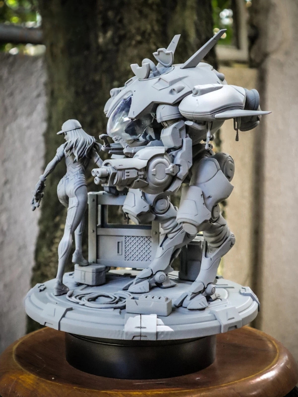 Detailed model of a robot and a person on a wooden stand with a blurred background