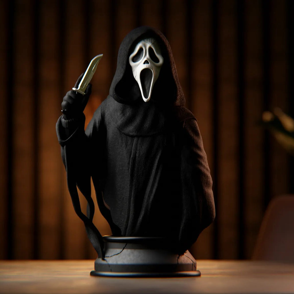 Statue of a character in a black hood holding a knife against a dark background
