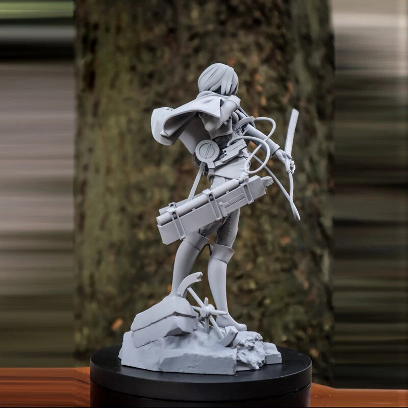 Gray statue of a character on a black pedestal against a blurred natural background