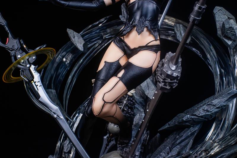 Statue of a character in black leather outfit with weapons on a dark background