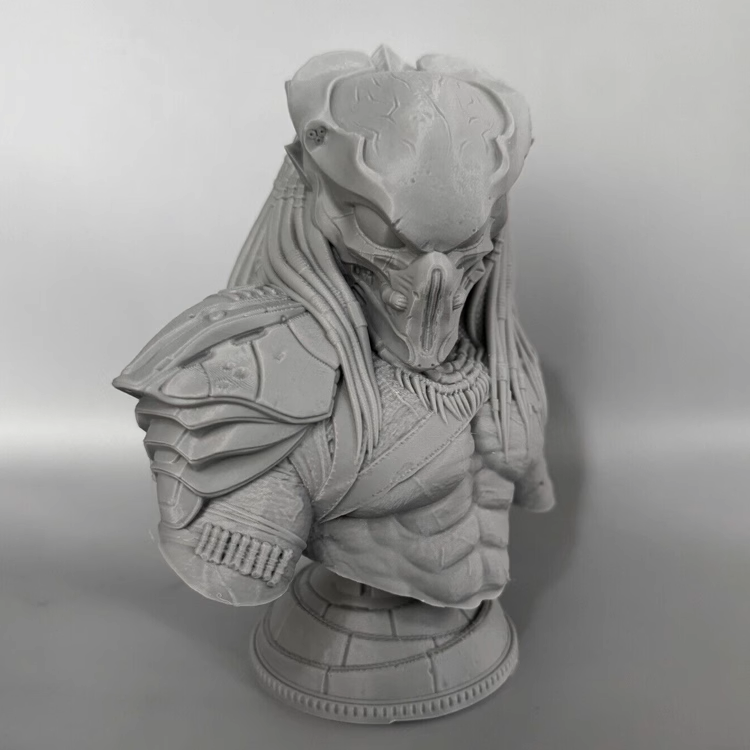 Gray scale bust of a predator warrior figure on a plain background