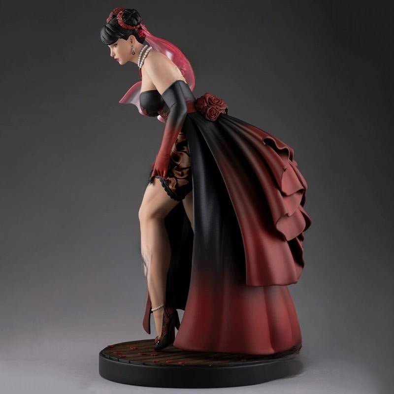 Statue of a woman in a red and black dress on a gray background