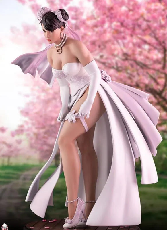 Woman in a white dress with long gloves standing in front of cherry blossom trees