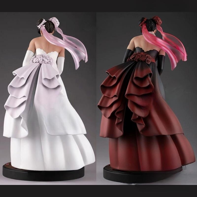 Two figurines in dresses with flowing hair on a dark background