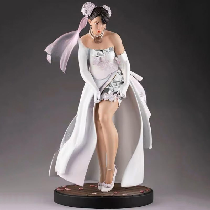 Statue of a woman in a detailed dress with a white cape on a gray background