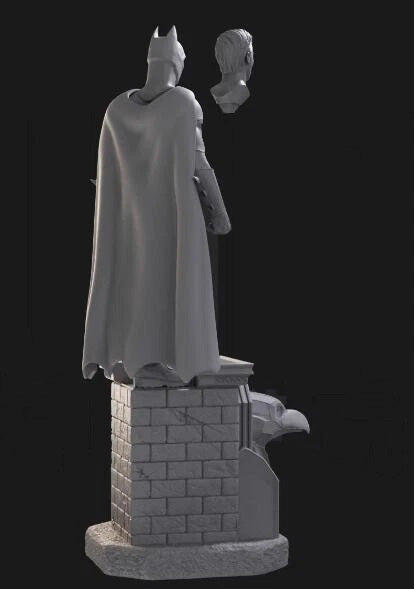 Statue of a superhero in a cape and mask on a pedestal with a dark background