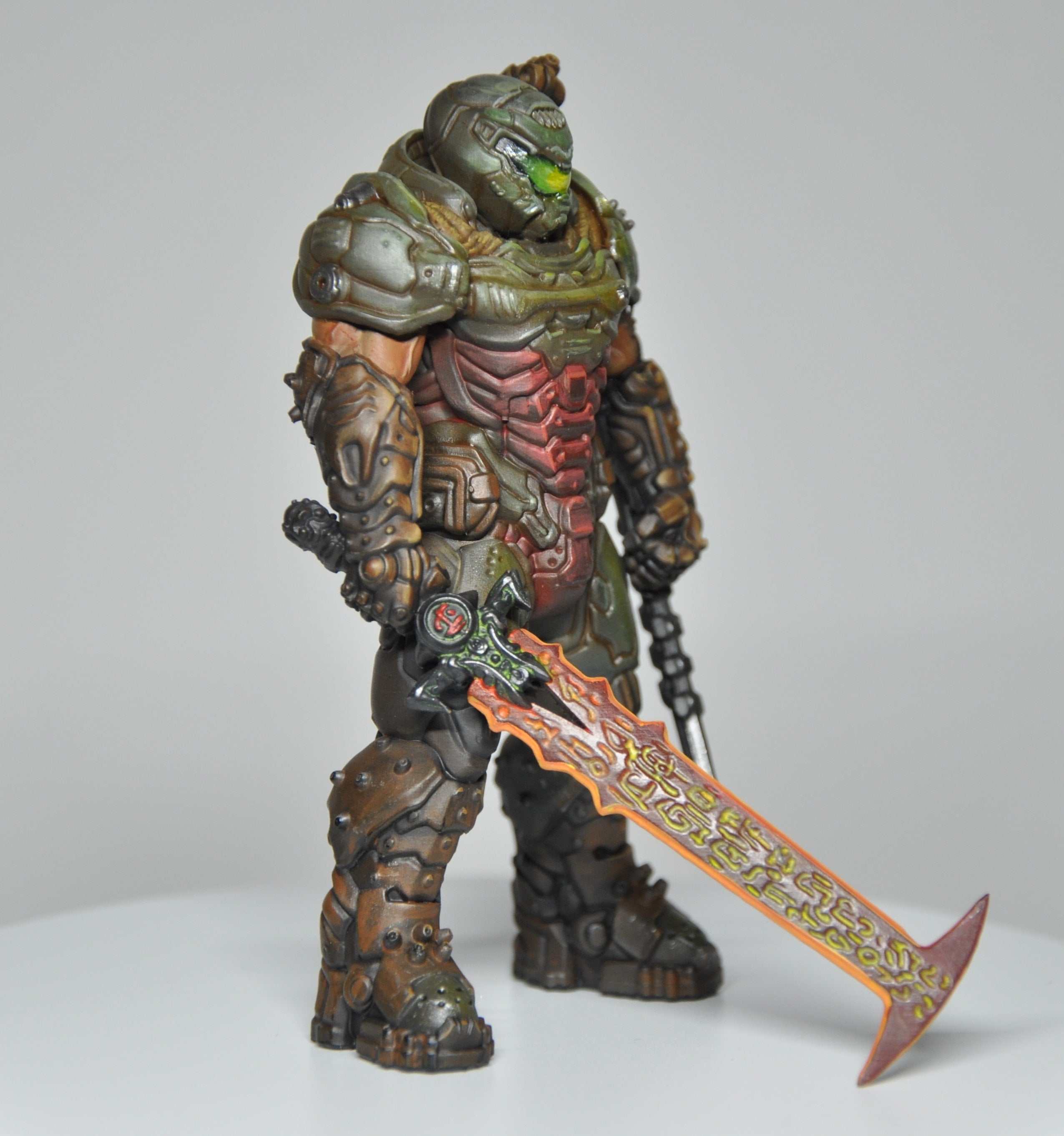 Toy figure of a warrior in detailed armor holding a sword on a gray background