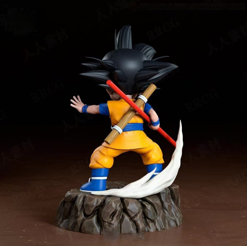 Figurine of a character in orange and blue outfit with a red weapon on a dark background