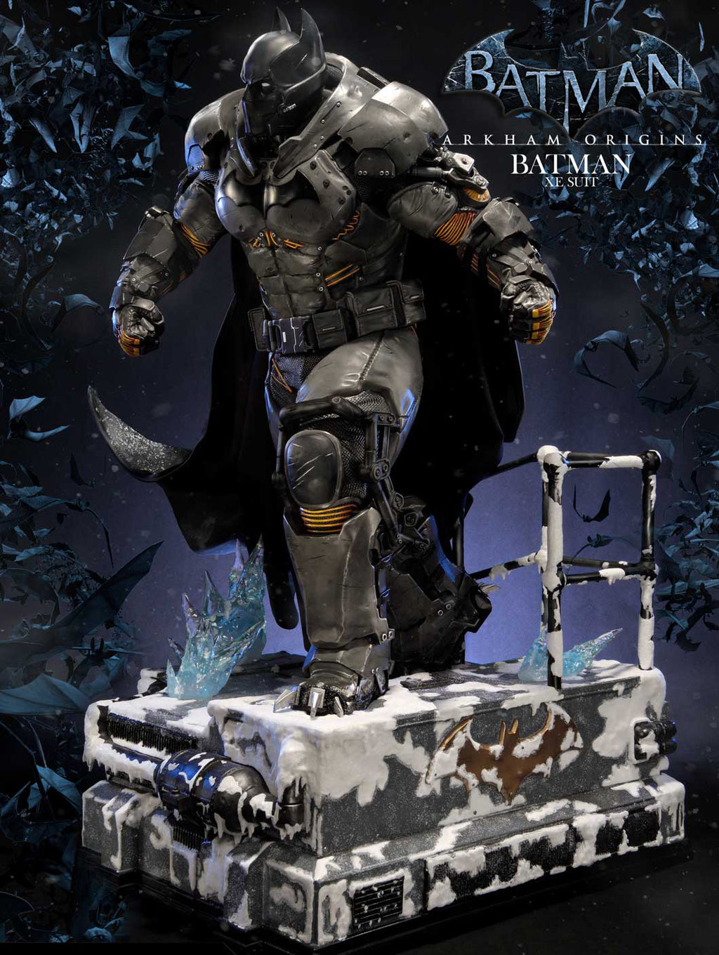 Batman Origins Batman in Steel collectible statue of Batman standing on a snowy utility box base, with Batman logo and Batman in Steel text in the background.