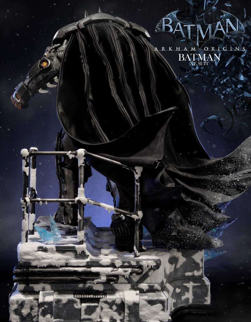 Batman Arkham Origins Batwing collectible statue in a snowy, industrial setting, featuring a large black bat-shaped winged motorcycle on a detailed gray and white base. The Batman Arkham Origins logo is visible in the top right corner.