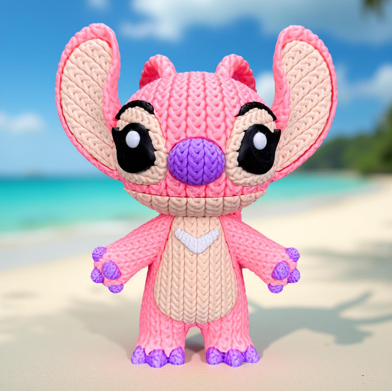Knitted plush toy resembling a character with pink and beige colors on a beach background