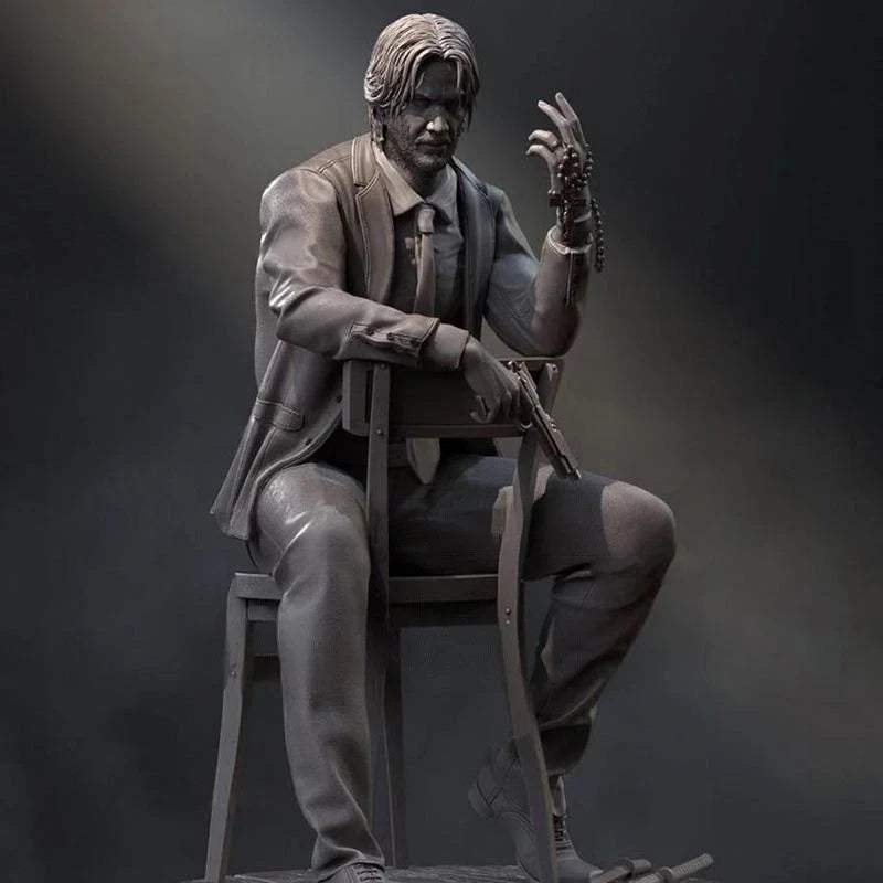 Statue of a person in a suit sitting on a chair against a dark background