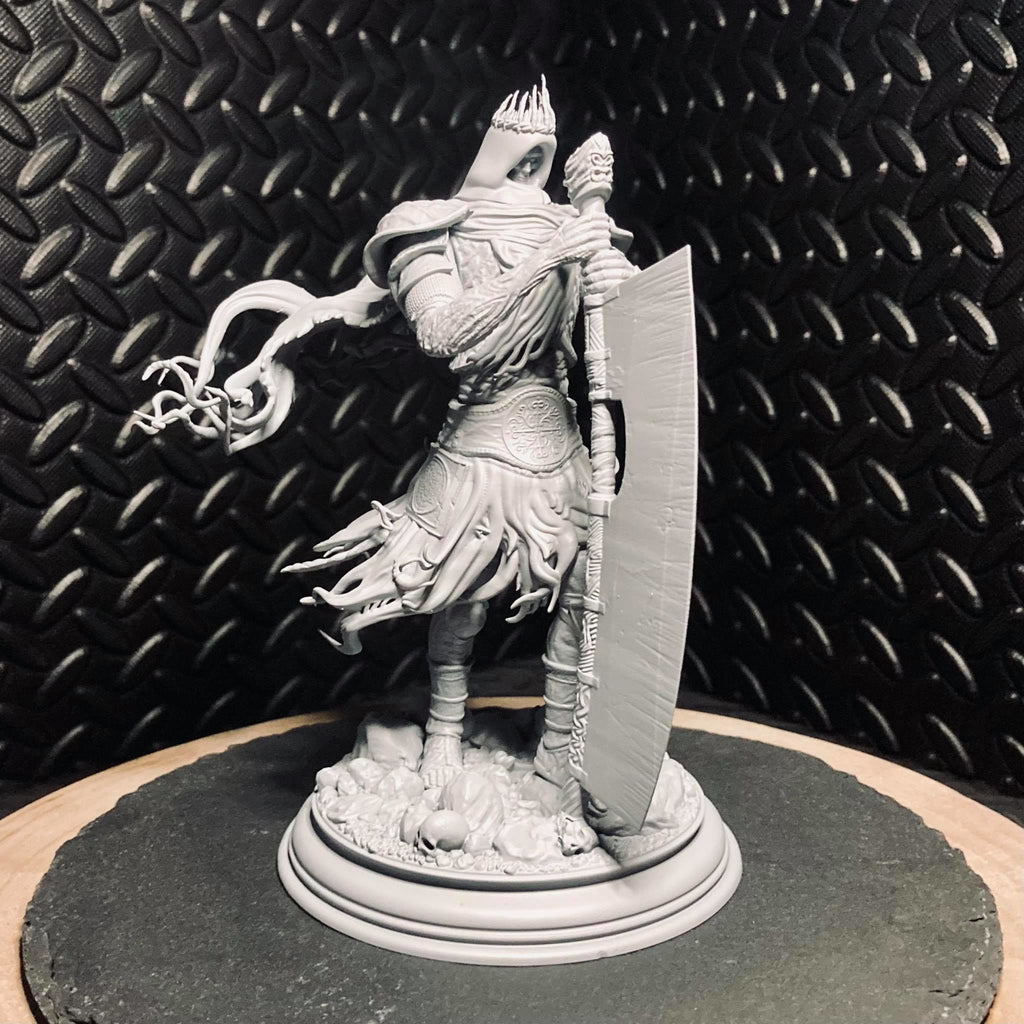 Warrior figurine with armor and shield on a round base against a textured black background